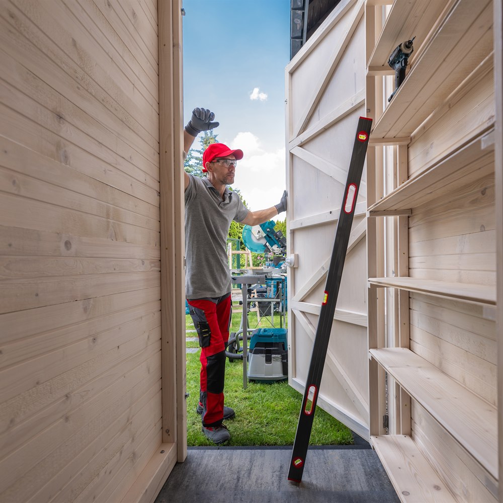 Adult man building storage shed doors outdoors