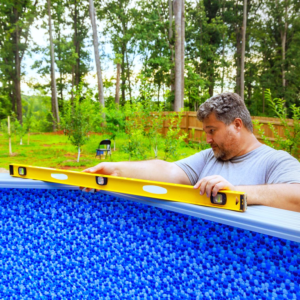 Adult man leveling an above ground swimming pool