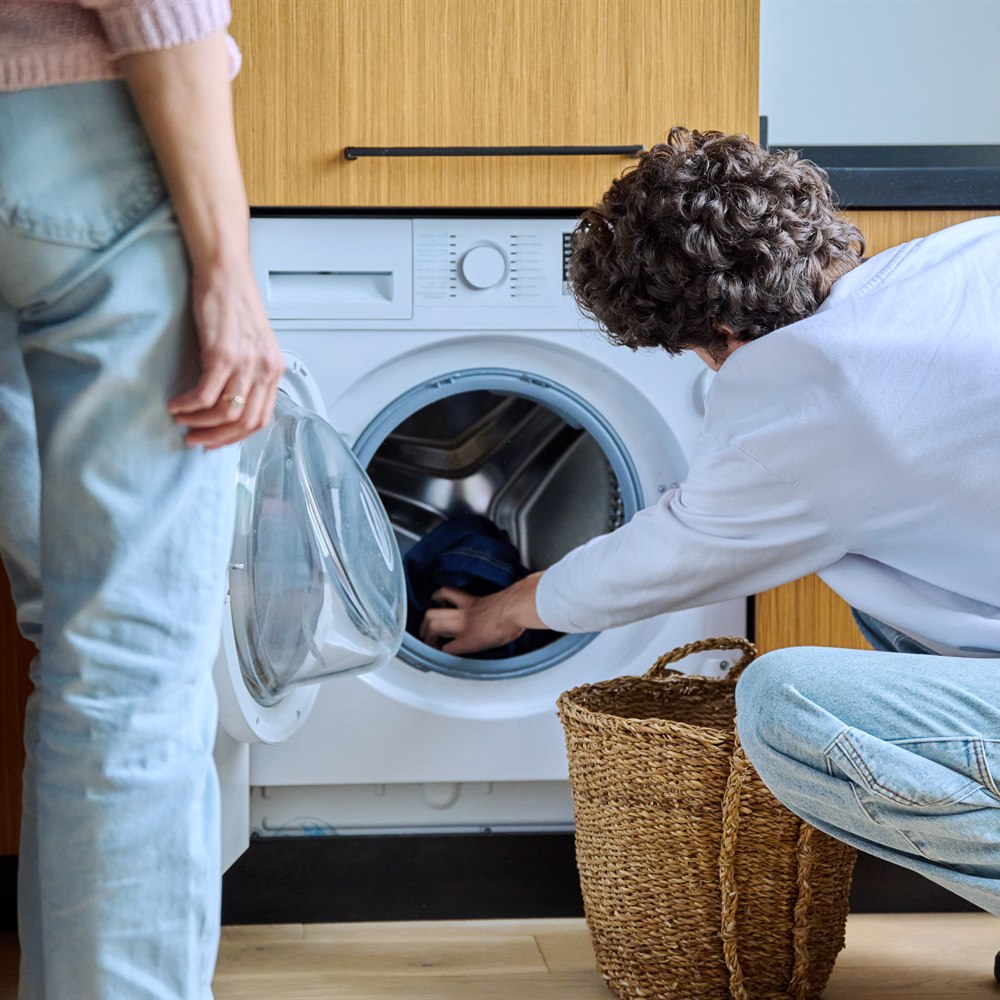 Adults doing laundry indoors in home setting