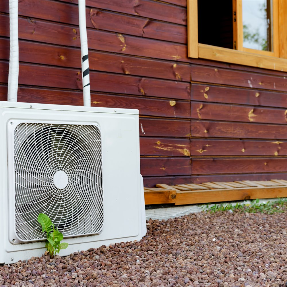 Air conditioner unit next to wooden house