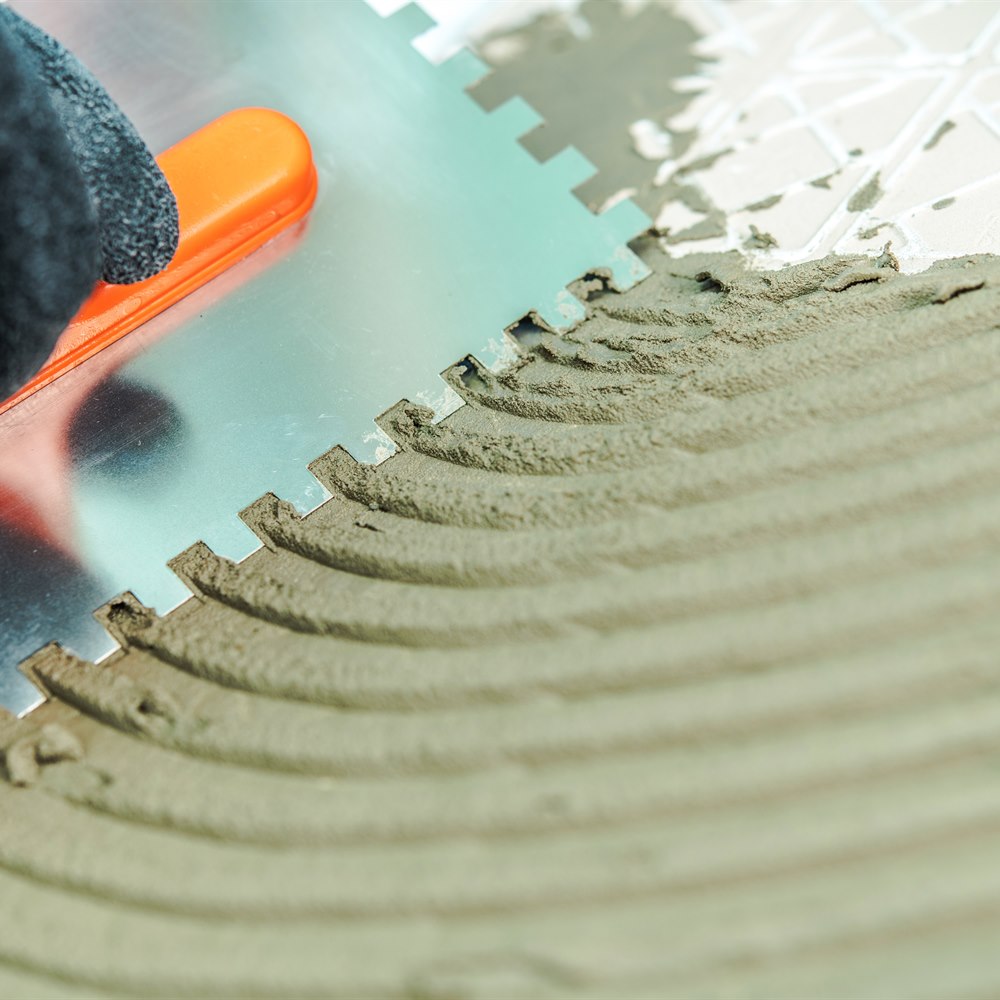applying-adhesive-for-tile-installation-with-trowe Applying adhesive for tile installation with trowel