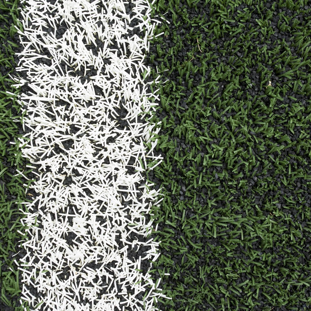 Artificial green grass background with white line