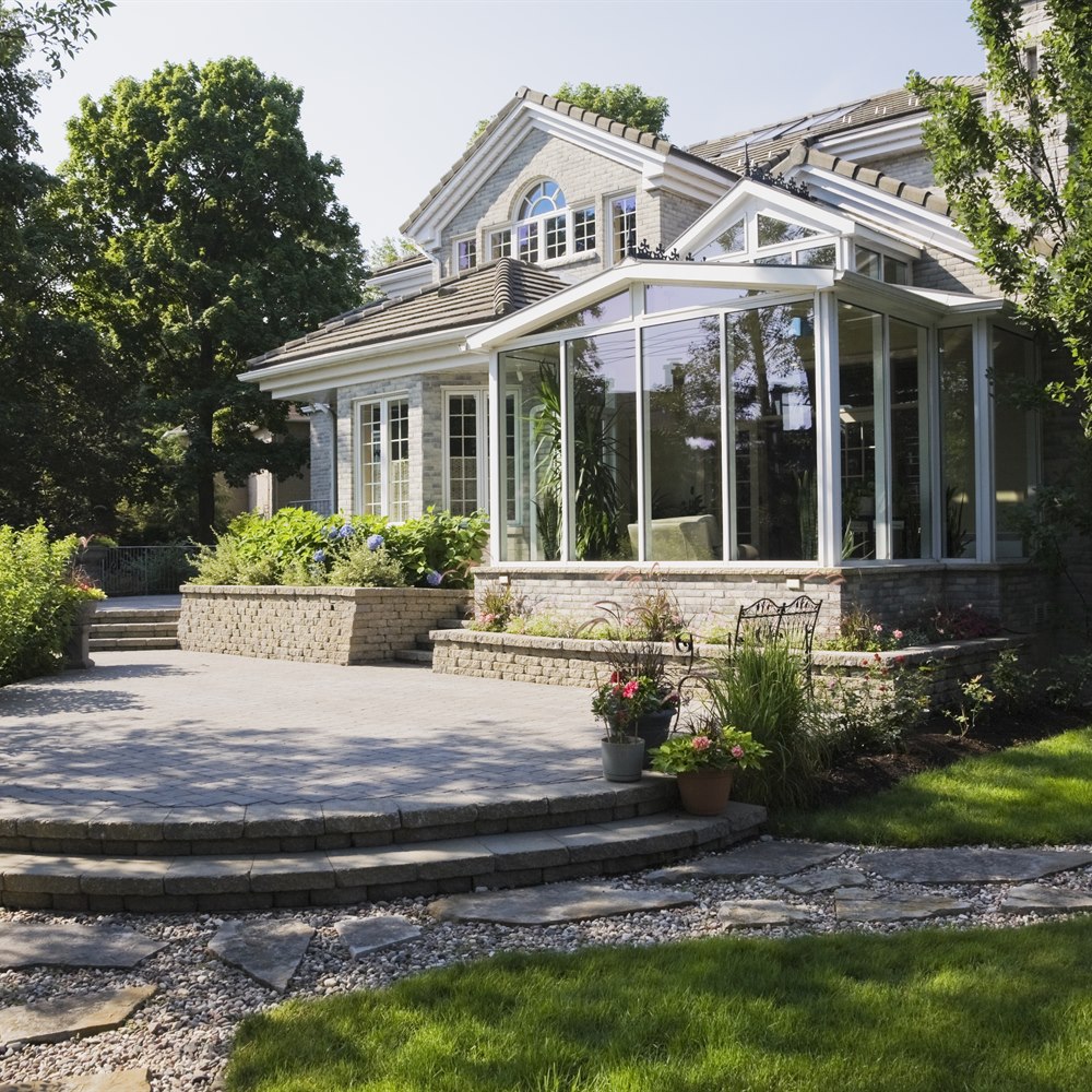 Brick and stone cottage style home with sunroom