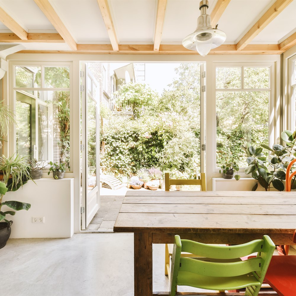 Bright dining room with greenery and wood details