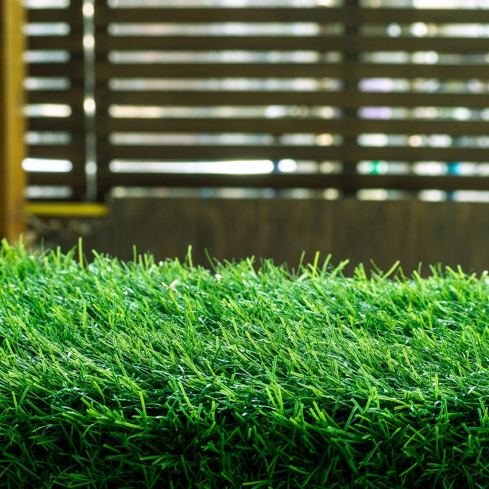 bright-green-artificial-turf-against-a-slatted-bac Bright green artificial turf against a slatted