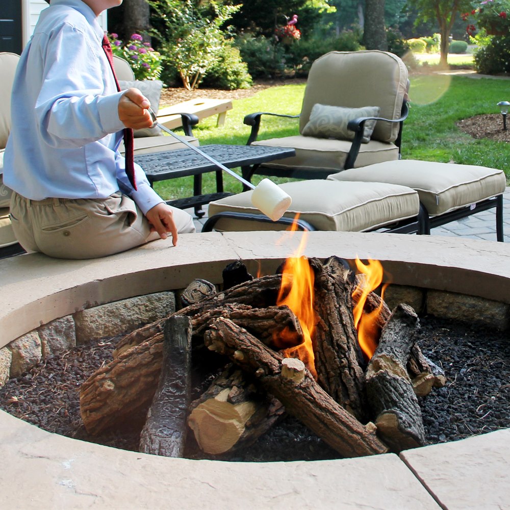 Child roasting marshmallow over outdoor fire pit