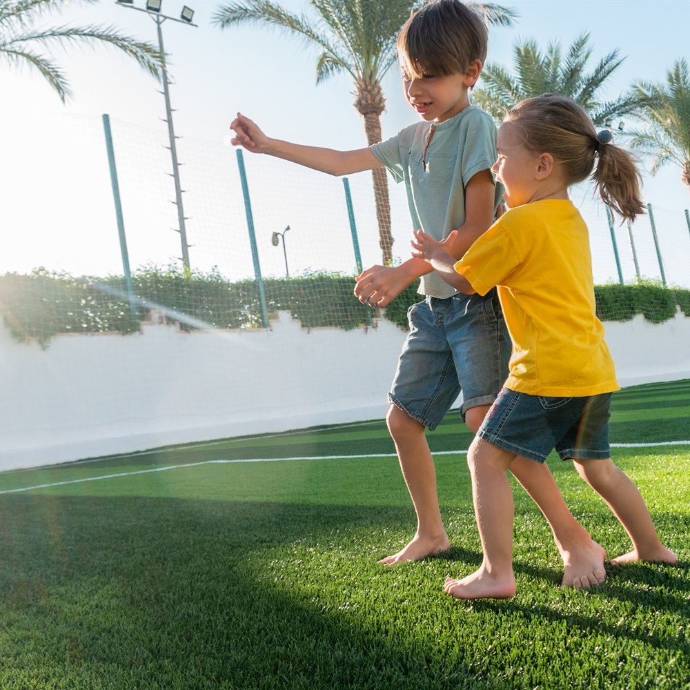 Children playfully kicking a ball in urban setting