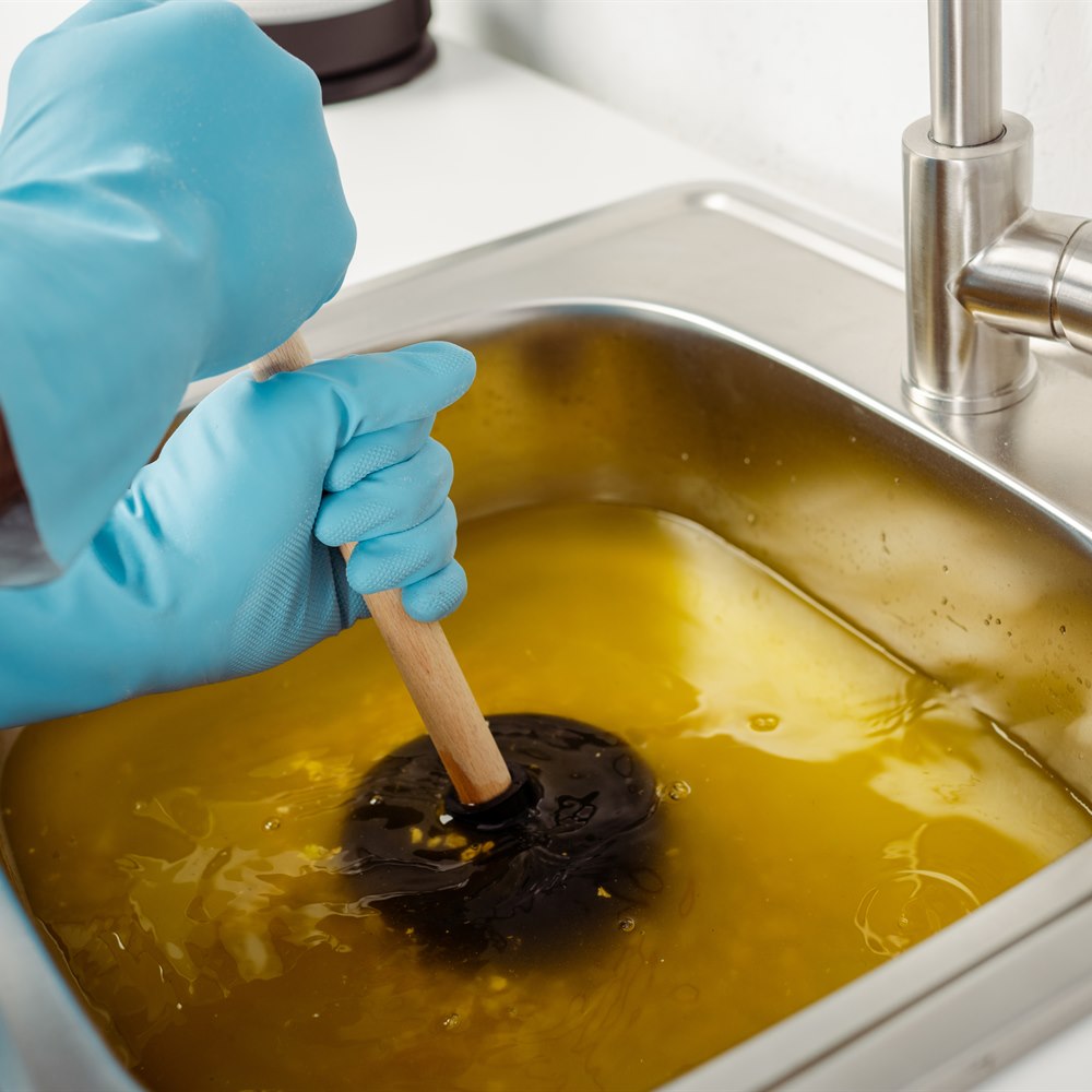 Clogged sink with gloves using a plunger
