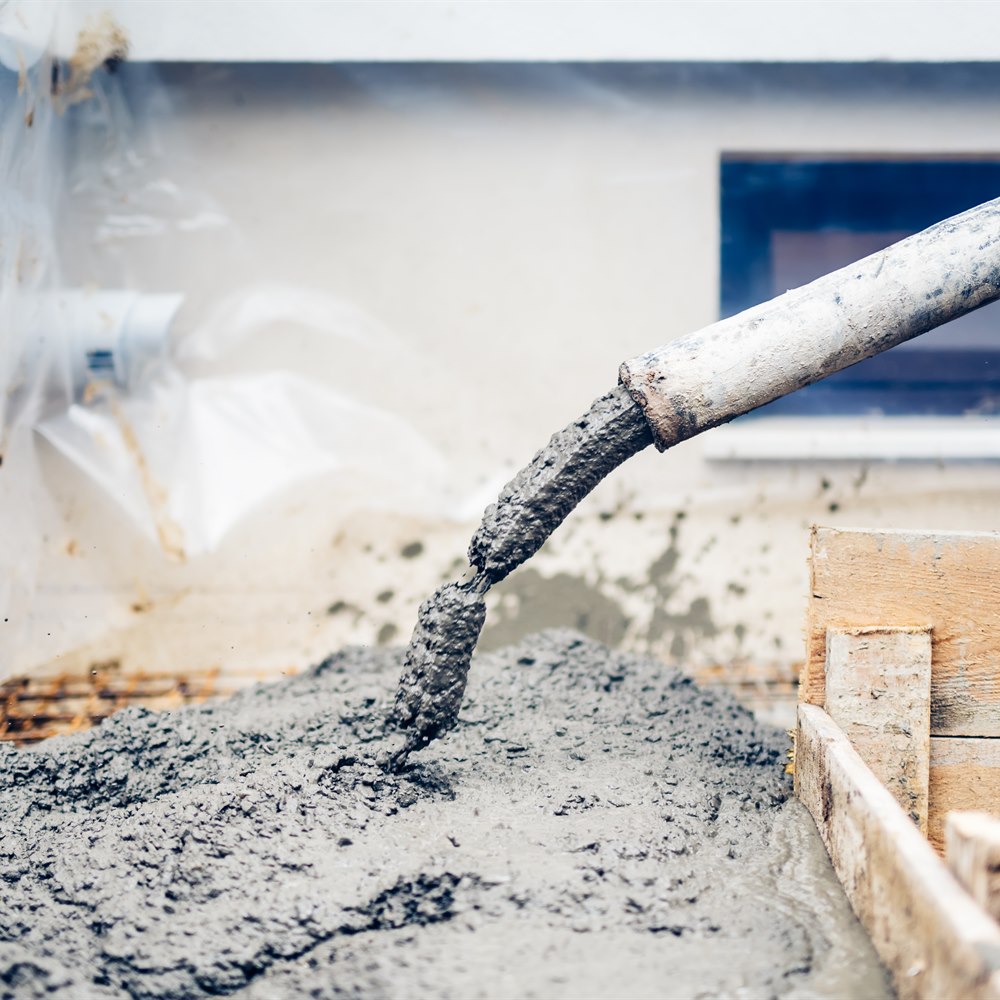 Concrete being poured into foundation form at construction