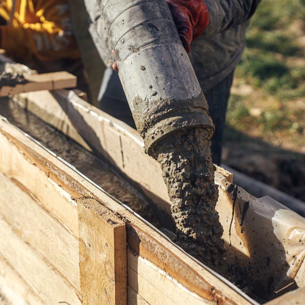 Concrete pouring into foundation form on construction