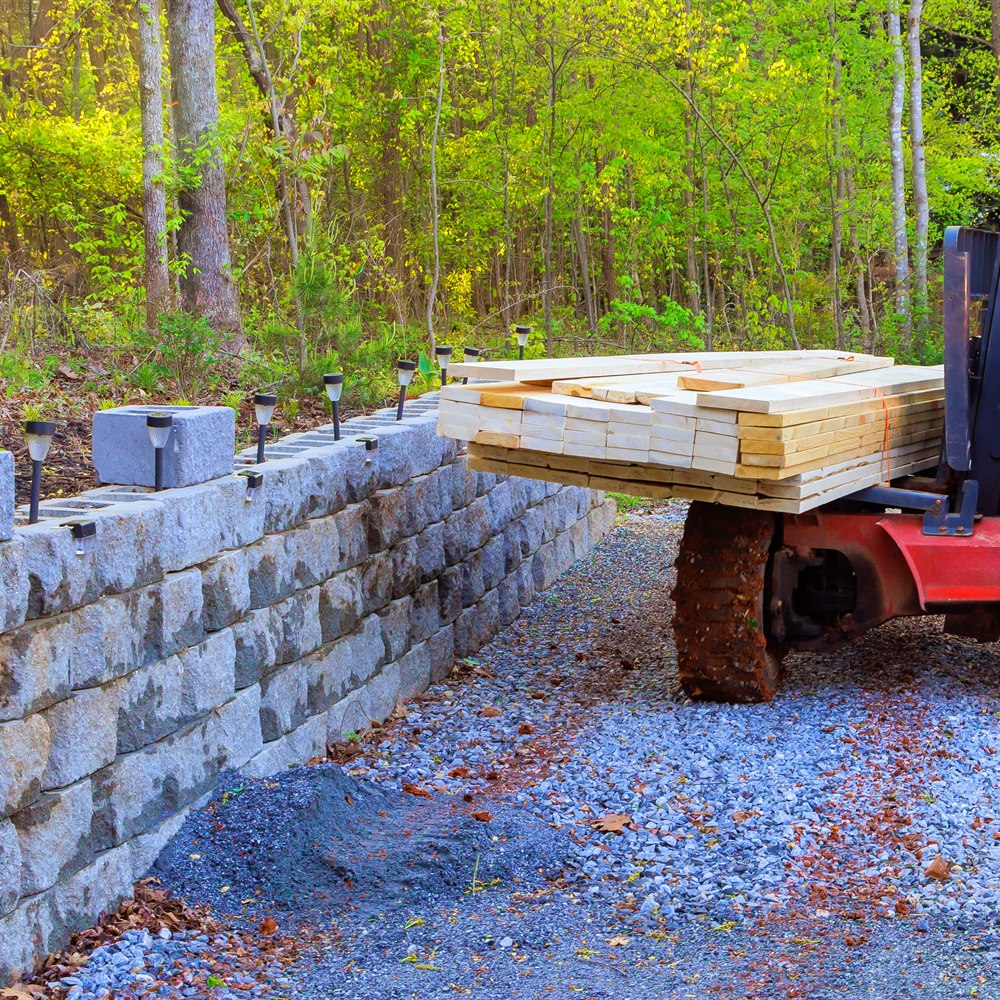 Construction vehicle lifting wood in rural setting