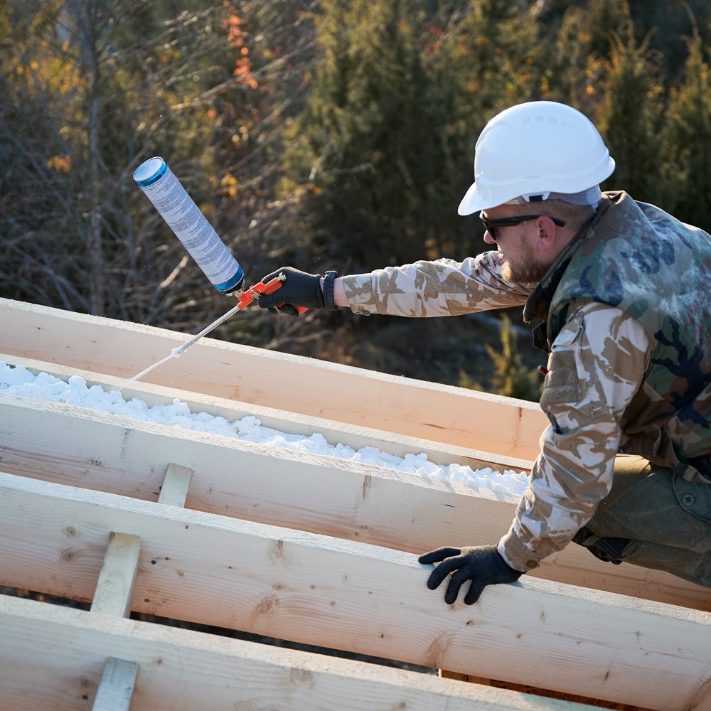 Construction worker applies insulation