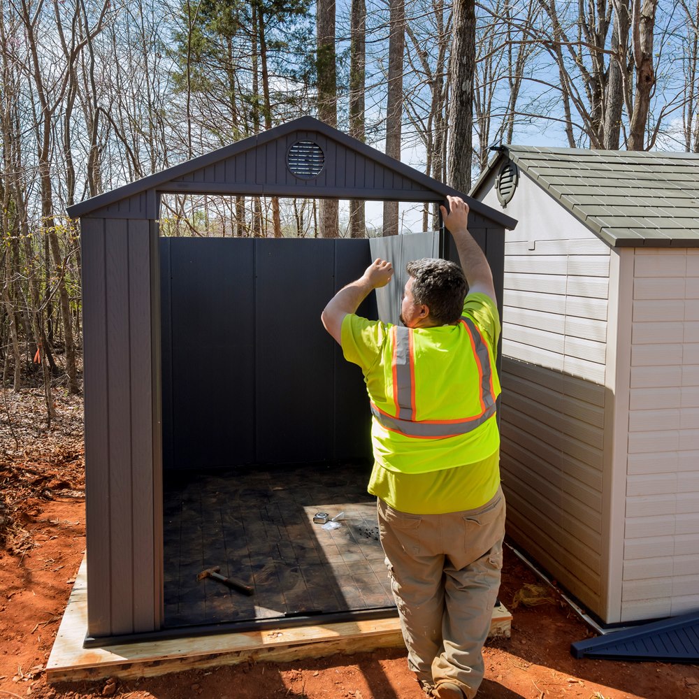 construction-worker-building-new-shed-in-a-yard Construction worker building new shed in a yard