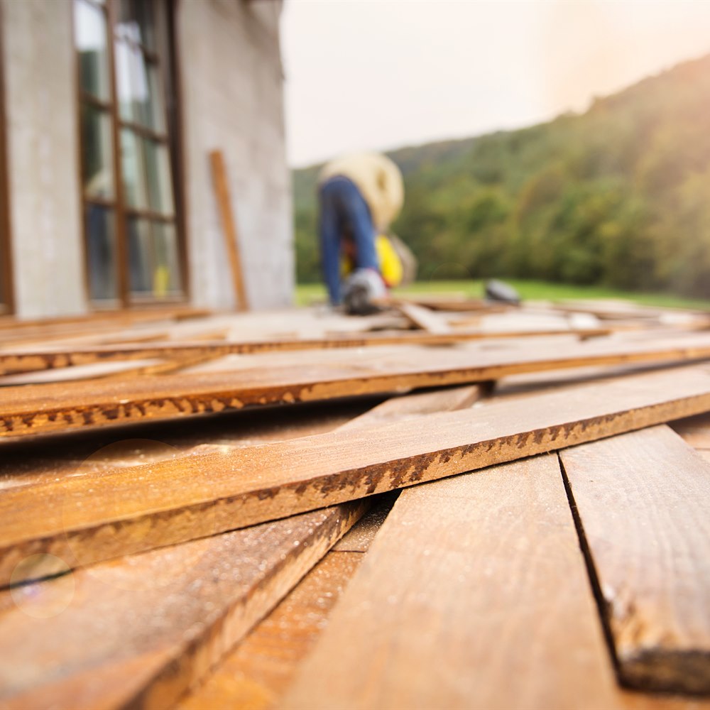 Construction worker building wooden deck