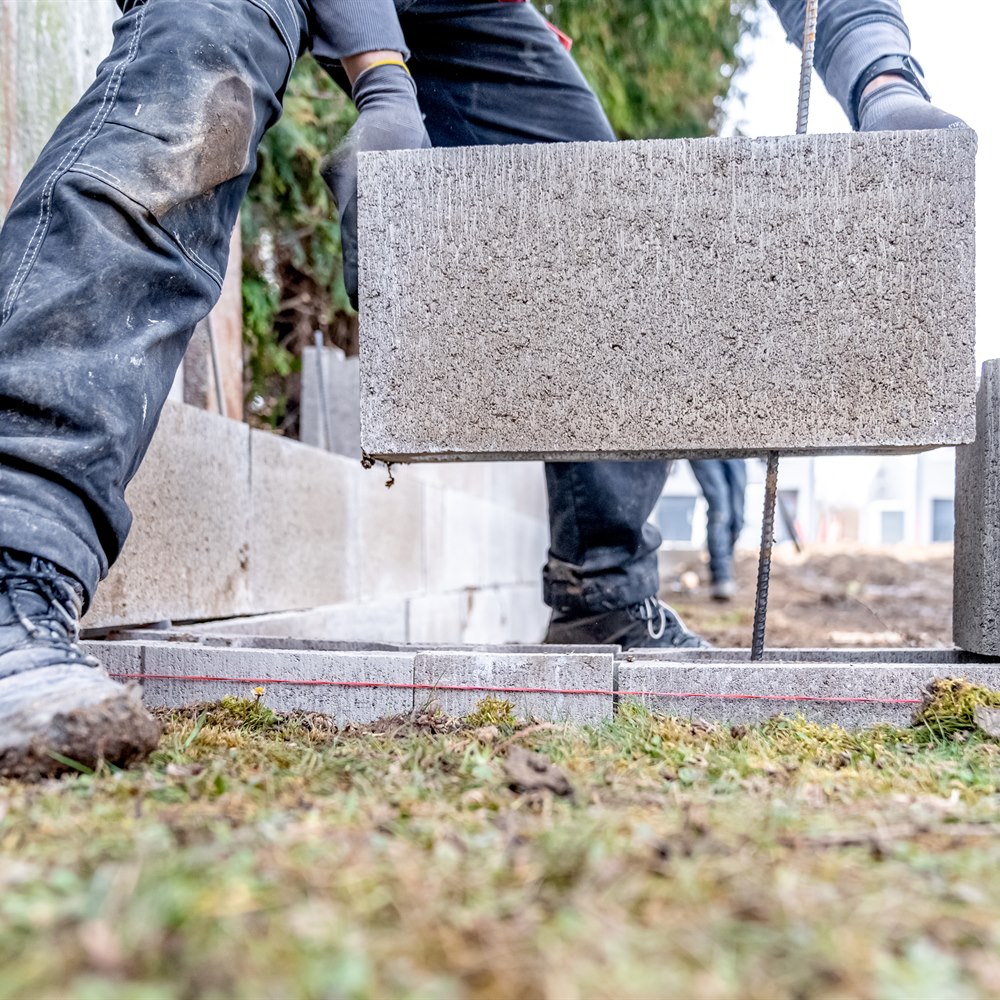 construction-worker-placing-cement-block-on-retain Construction worker placing cement block on retaining