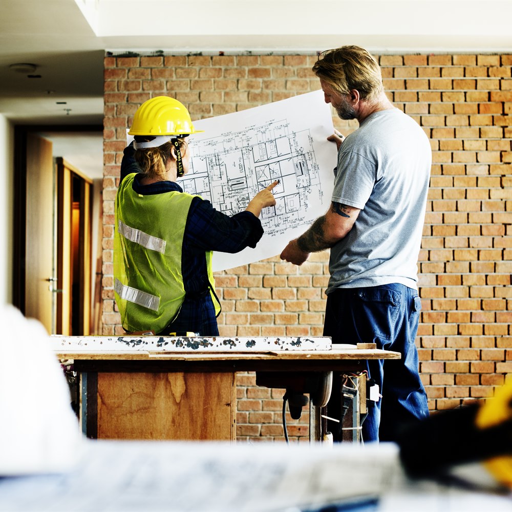 Construction workers reviewing blueprint in building