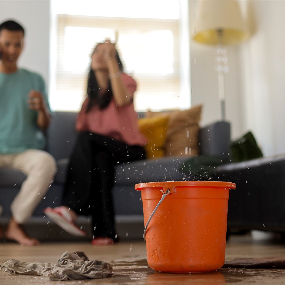 couple-dealing-with-water-leak-in-living-room Couple dealing with water leak in living room