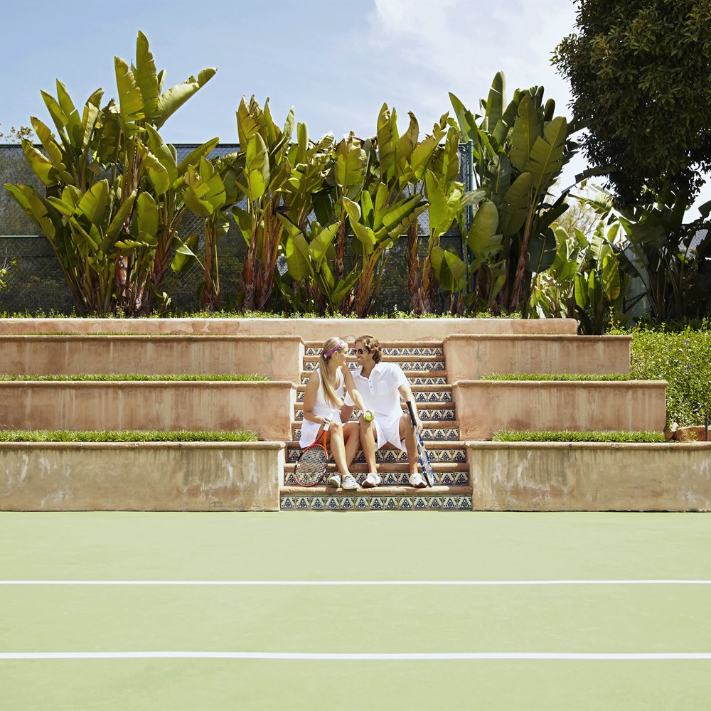 Couple relaxing on steps after tennis match