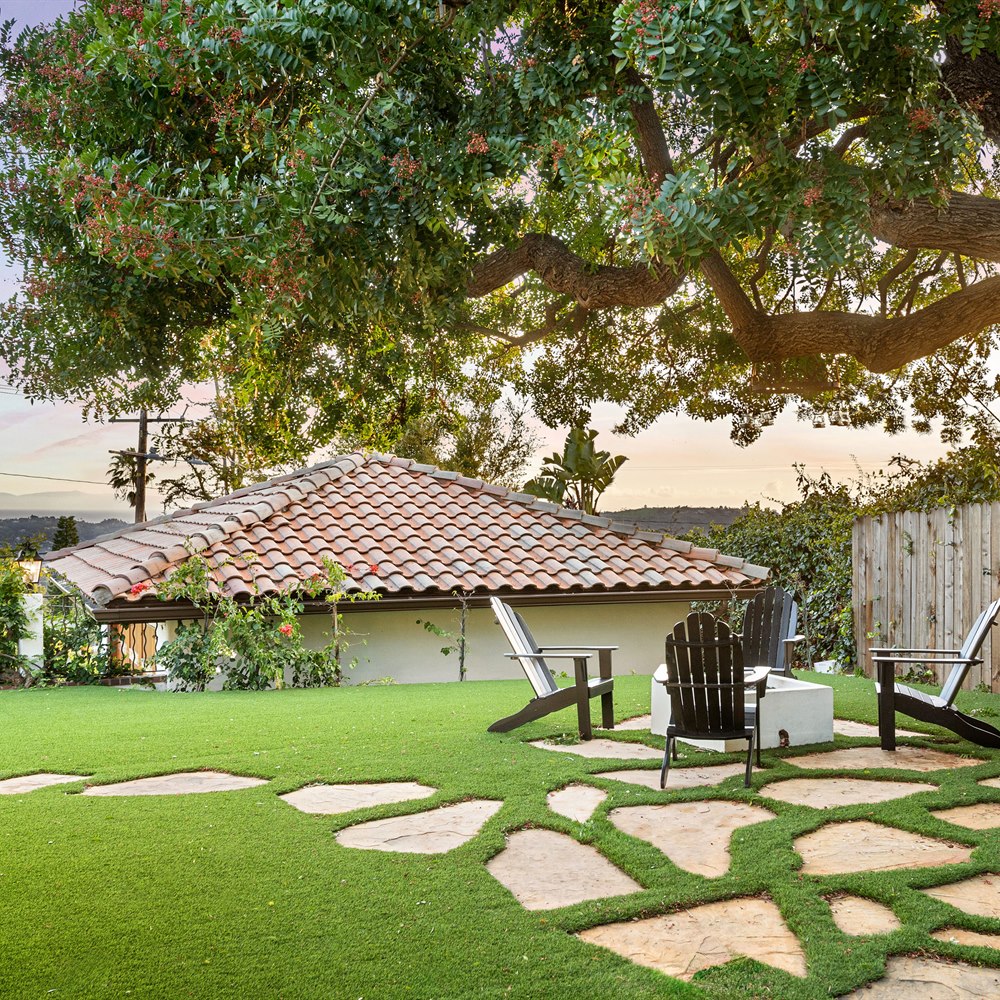 Cozy backyard with fire pit underneath a tree