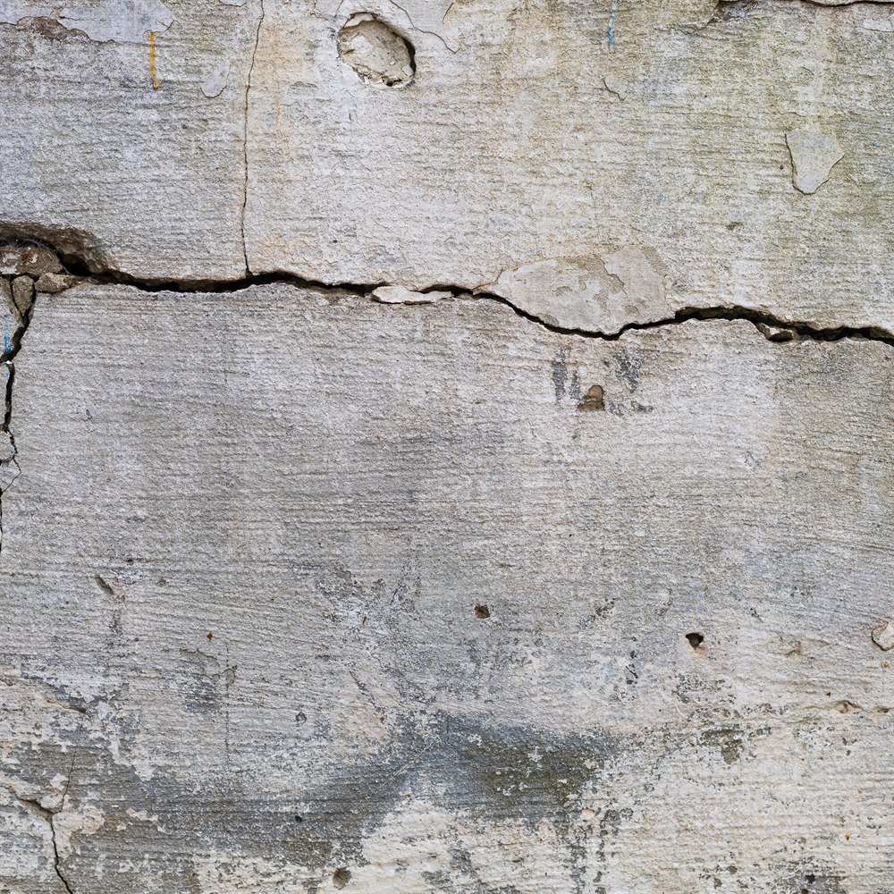 Cracked wall with weathered texture and gray hue