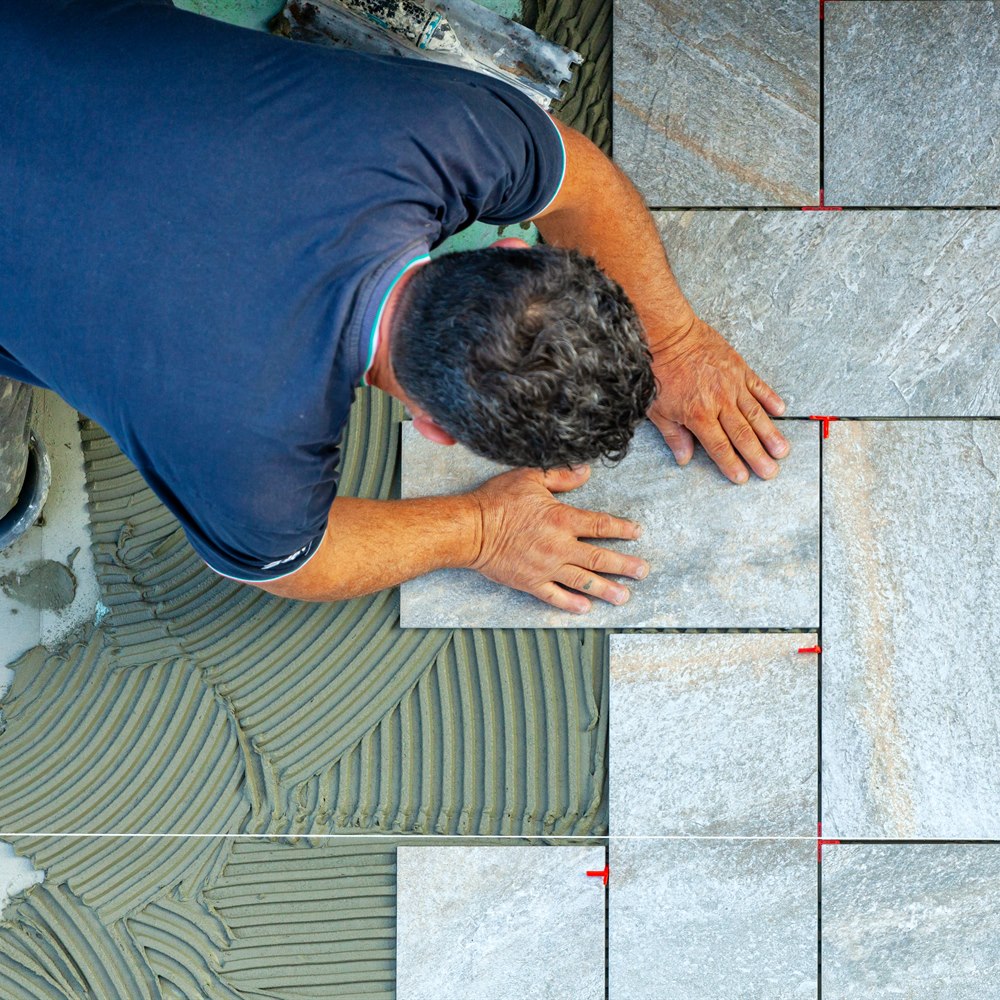 Craftsman installing stone floor tiles professional