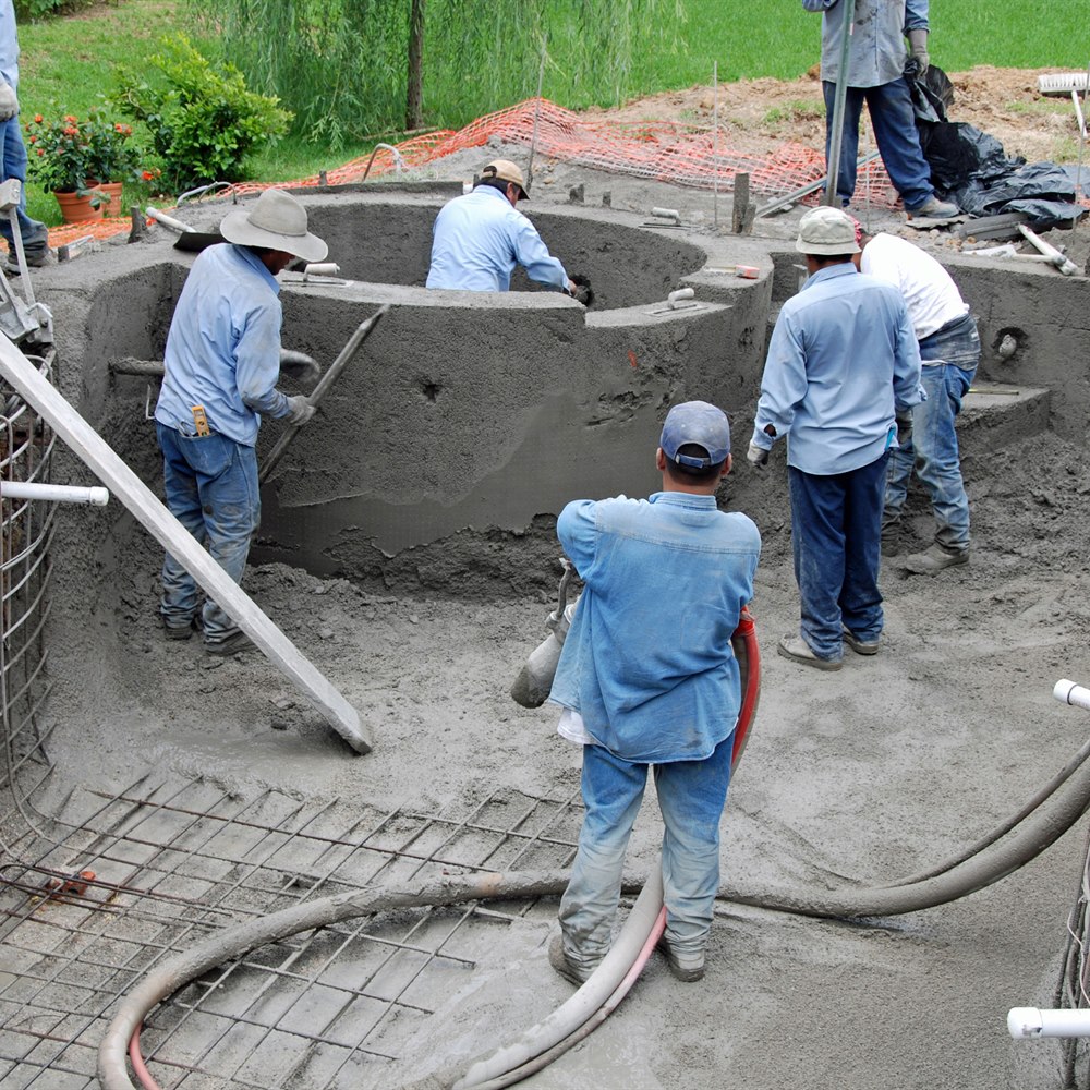 Crew spraying a concrete pool shell