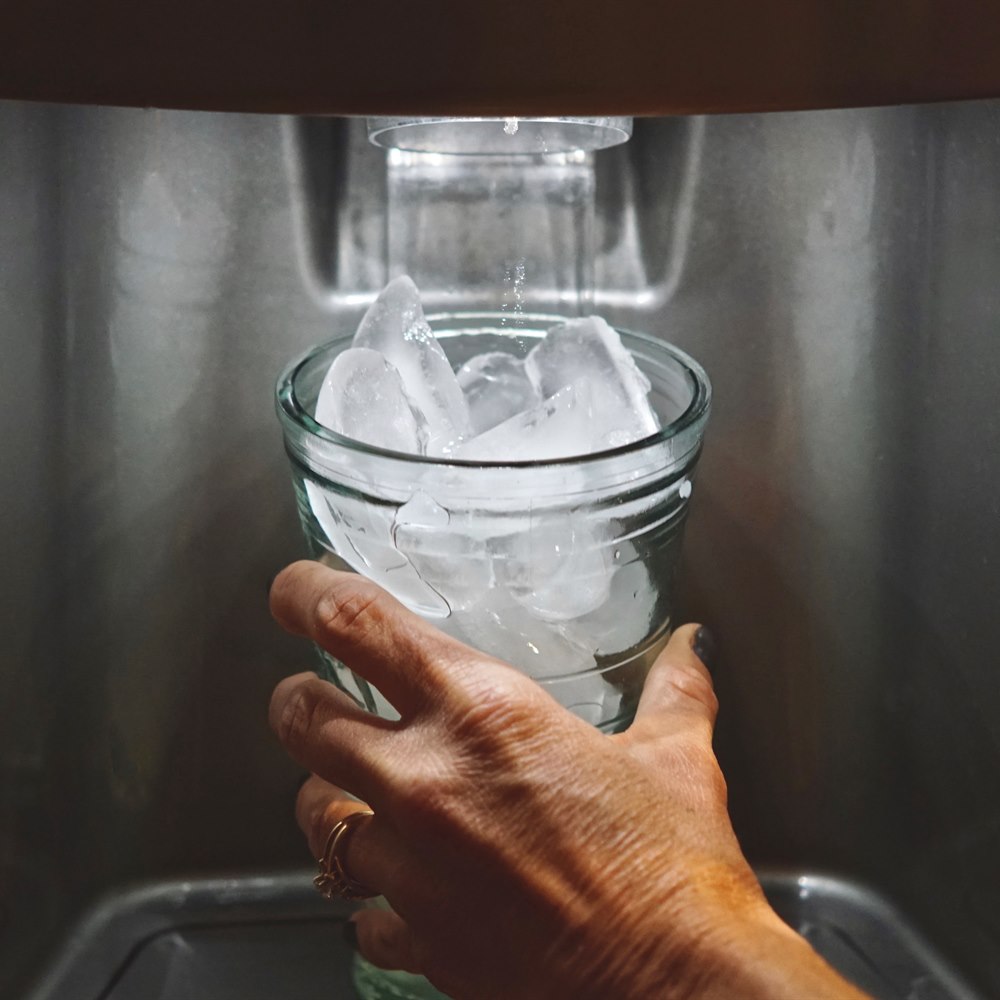 Dispensing ice into a glass in kitchen