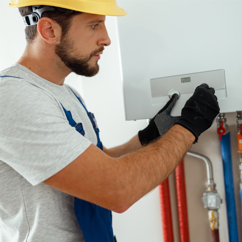 Engineer repairing water heater in gloves