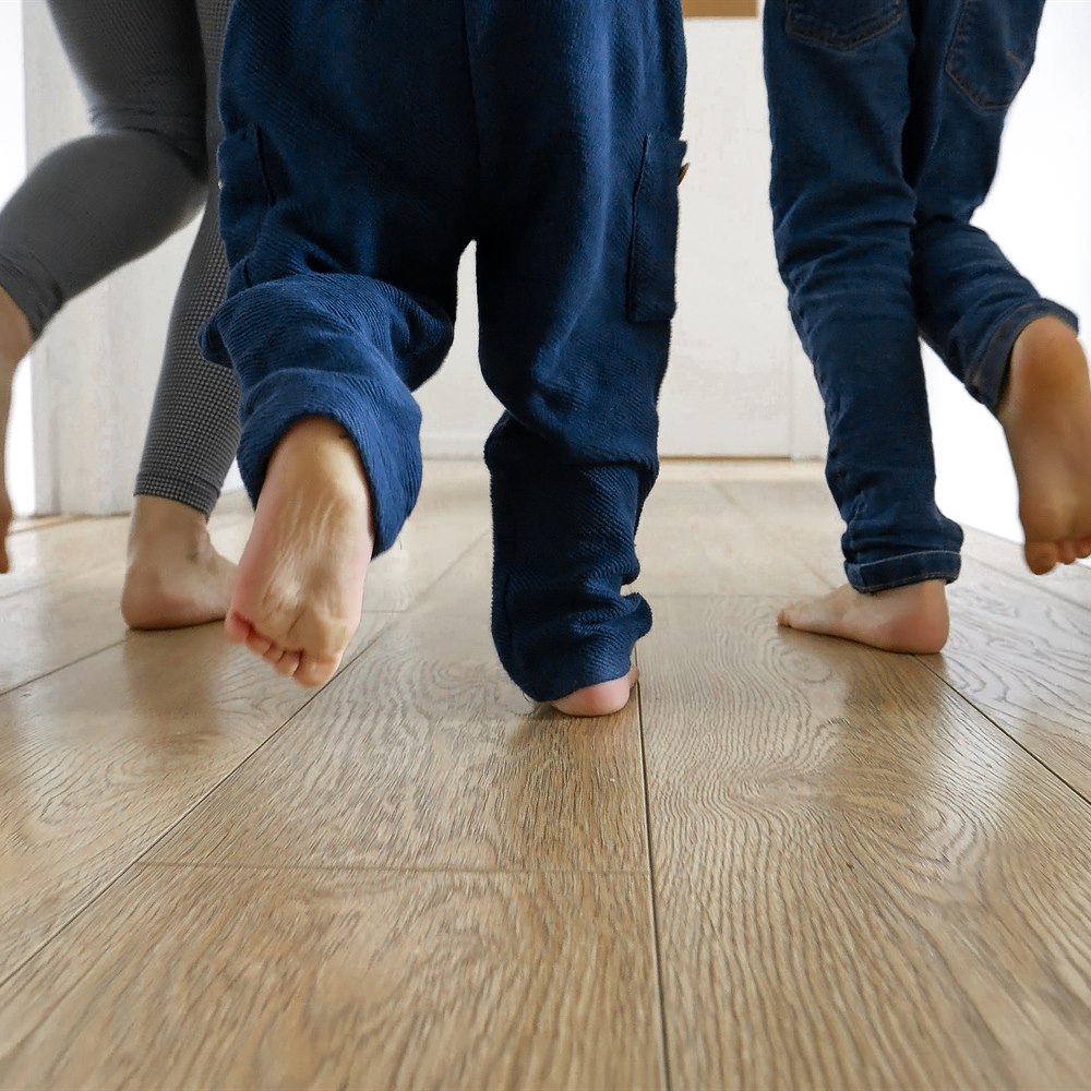 Family feet walking on wood floor at home
