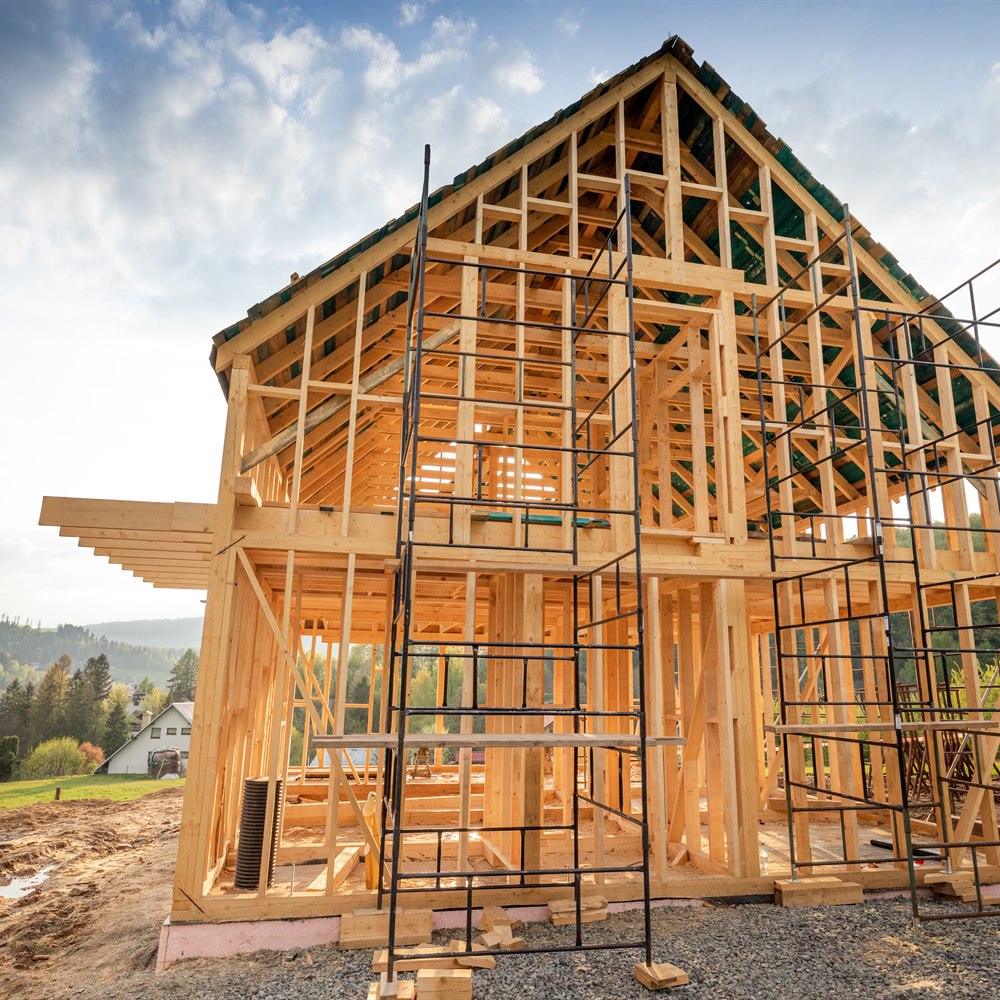 framed-house-under-construction-in-a-rural-setting Framed house under construction in a rural setting