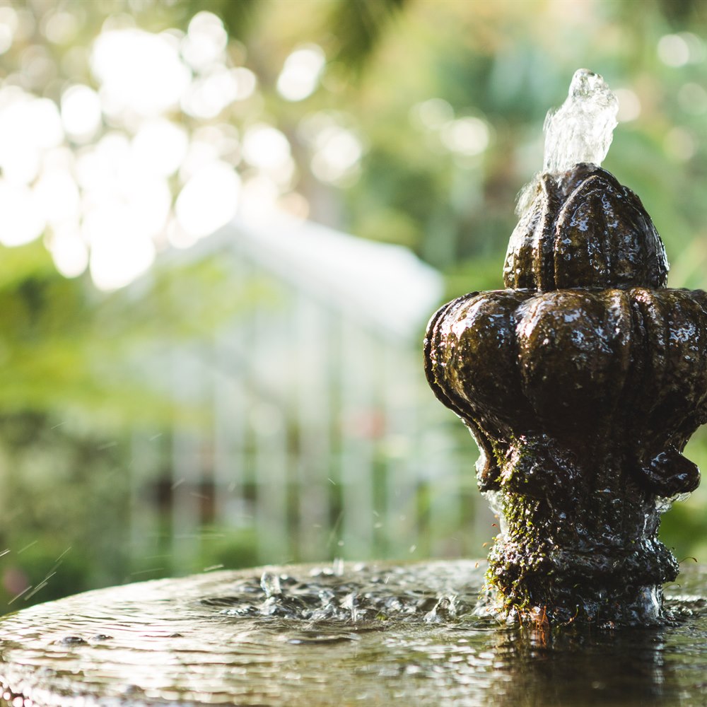 Garden fountain with water bubbling in outdoor set