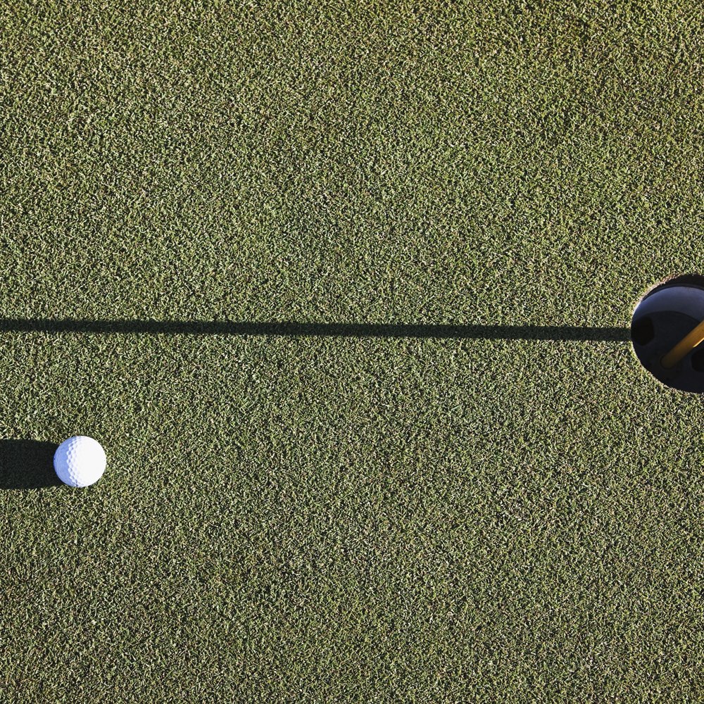 golf-ball-near-hole-on-green-course Golf ball near hole on green course