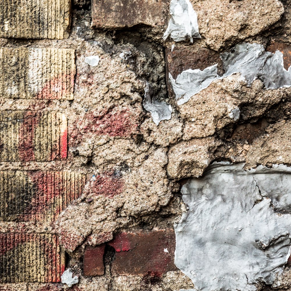 Gritty brick wall with peeling concrete texture