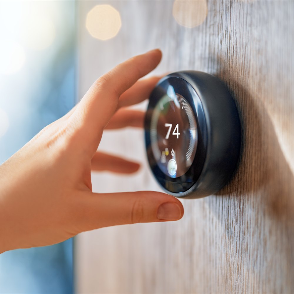 Hand adjusting smart home technology thermostat