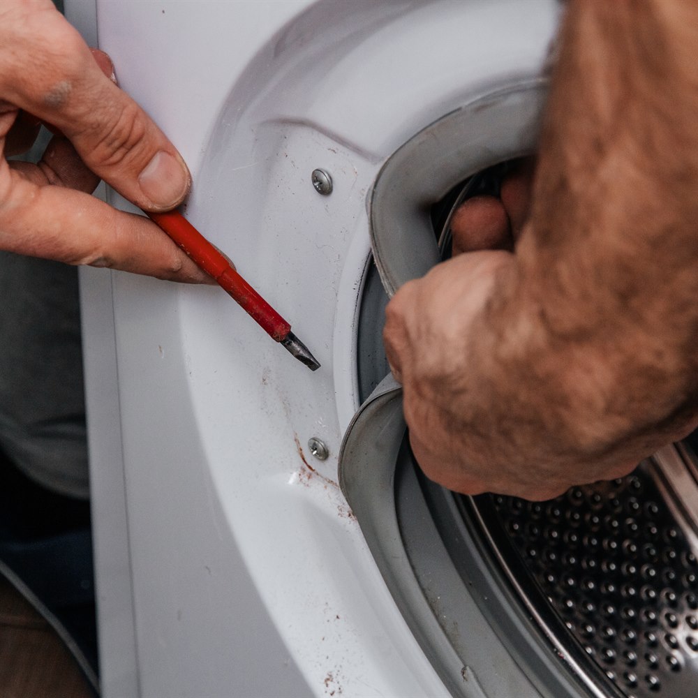 Handyman repairing a washing machine the hands