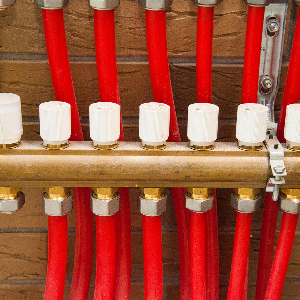 Heating system with red pipes and brass fixtures