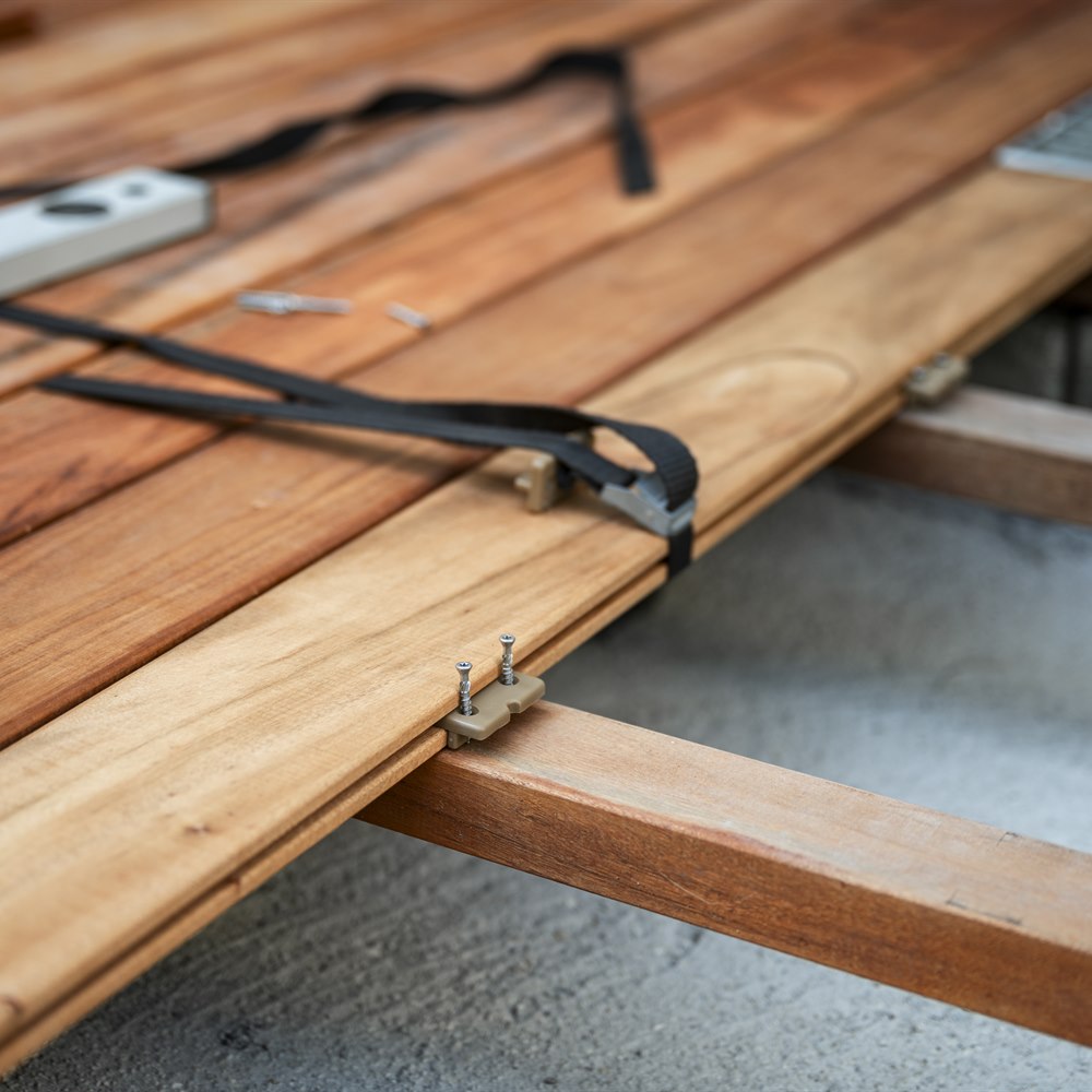 Installing wood decking planks on concrete patio