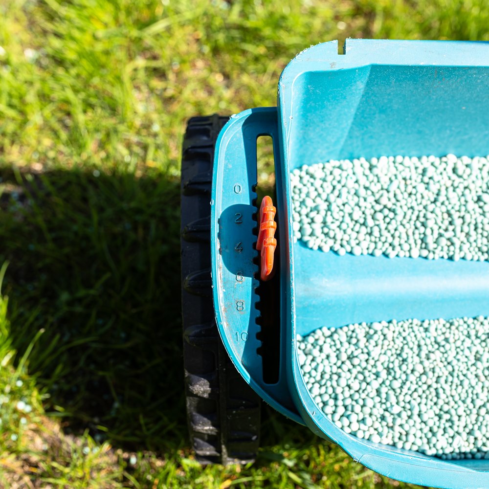 Lawn care spreader on green grass