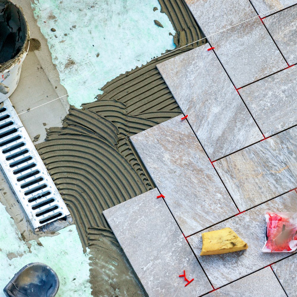 Laying grey tiles in a herringbone pattern