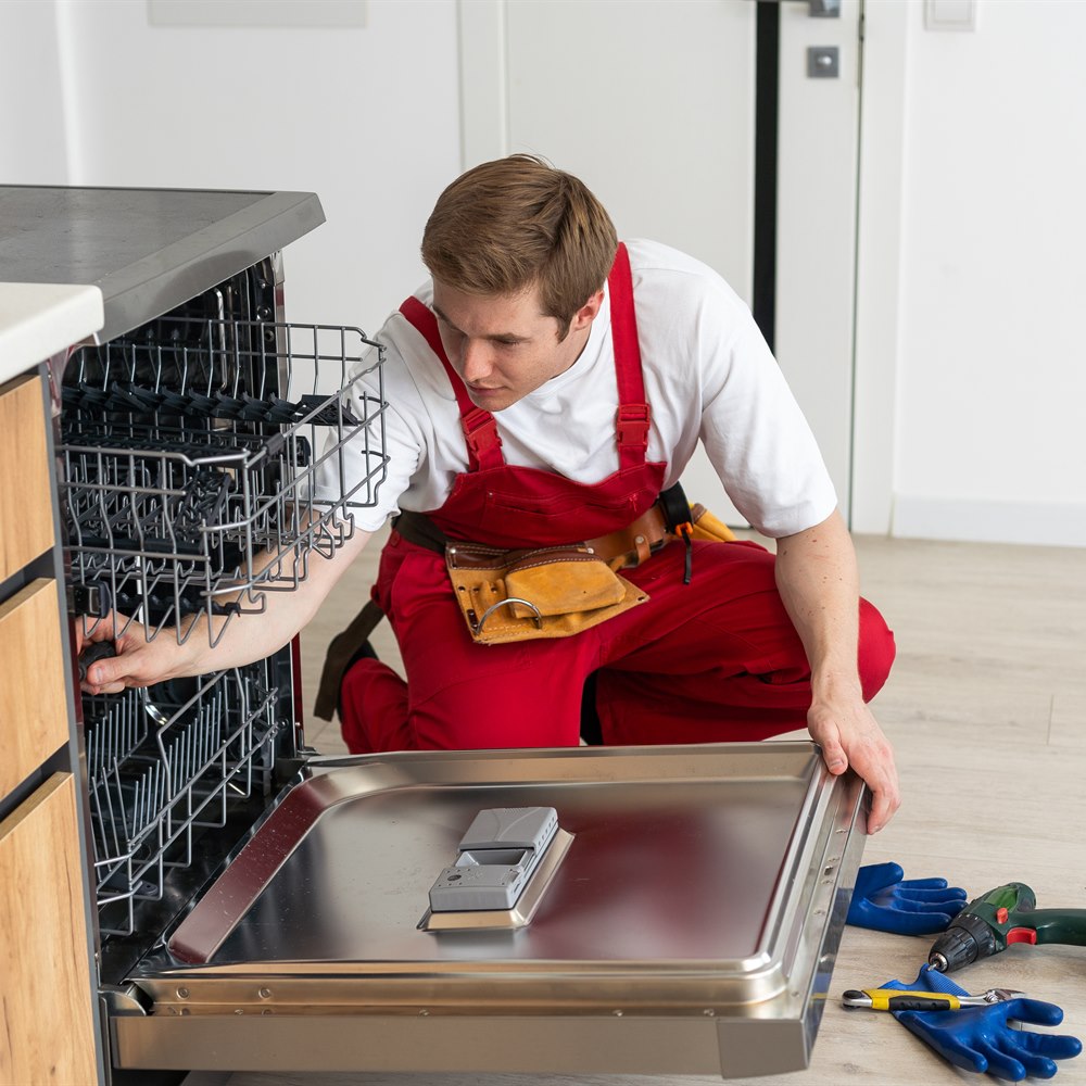 Maintenance man working on a dishwasher appliance