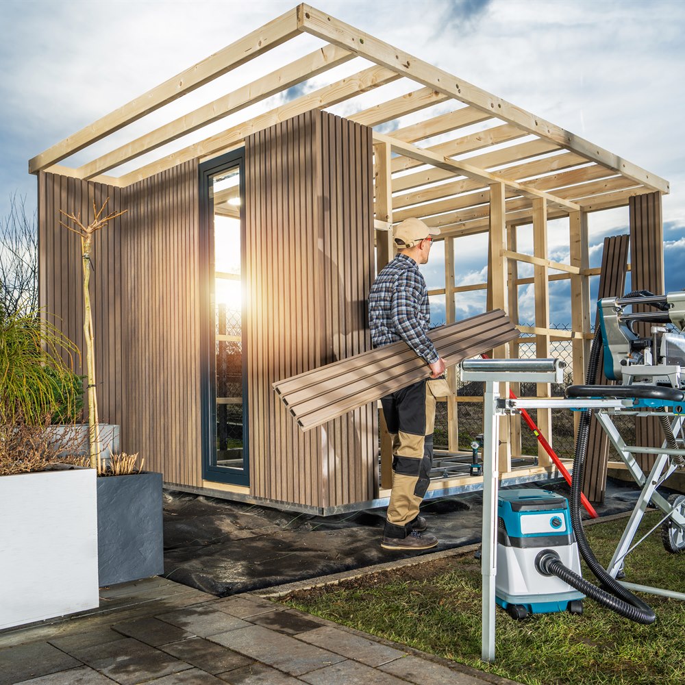 man-assembling-prefabricated-modern-garden-shed Man assembling prefabricated modern garden shed