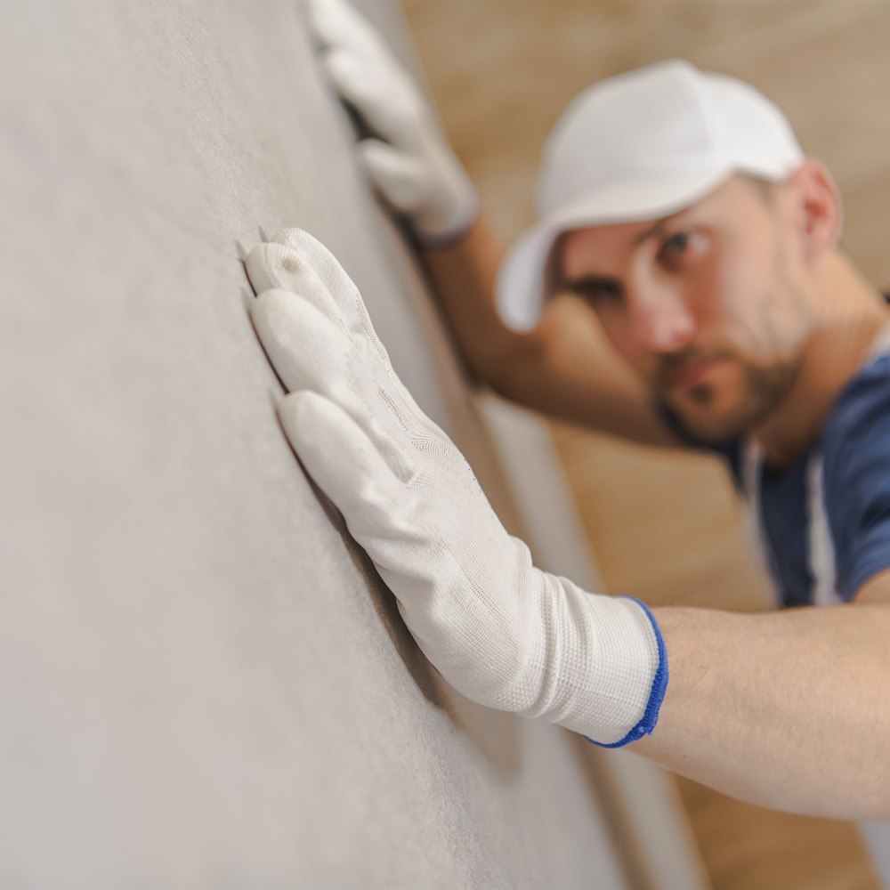 man-fitting-a-wall-panel-in-a-home Man fitting a wall panel in a home