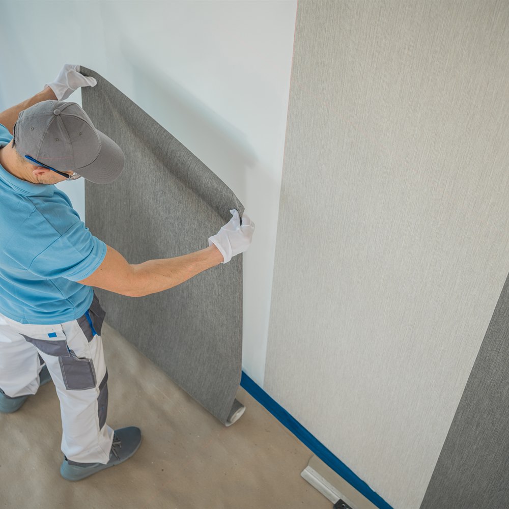man-installing-wallpaper-in-an-interior-space Man installing wallpaper in an interior space