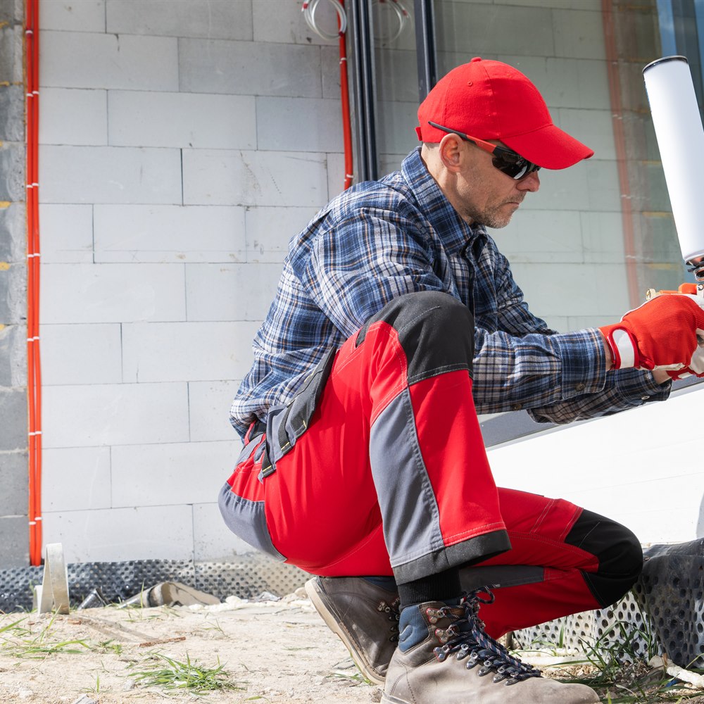 man-installing-window-with-expanding-foam-outdoors Man installing window with expanding foam outdoors