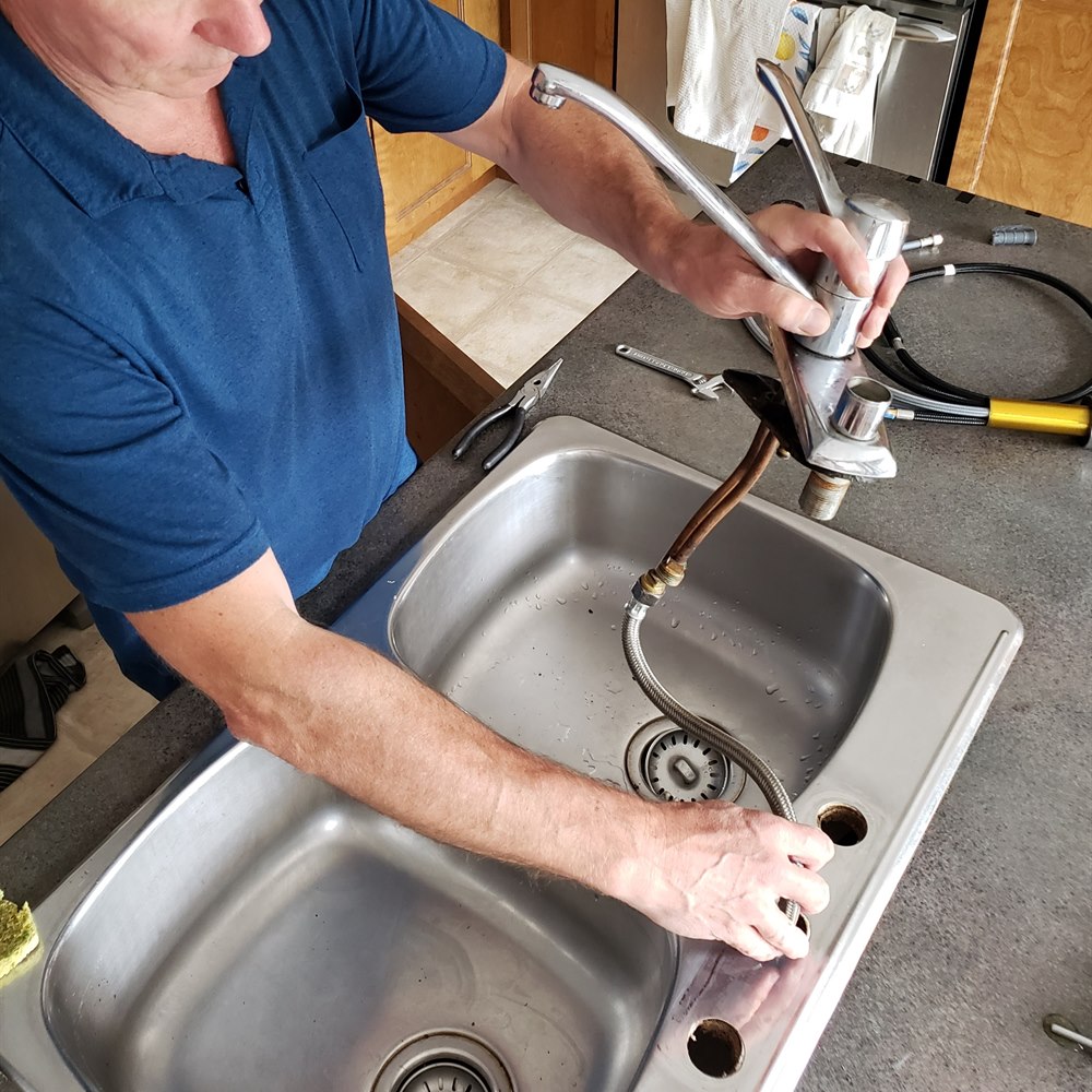 Man installs a shiny new kitchen faucet