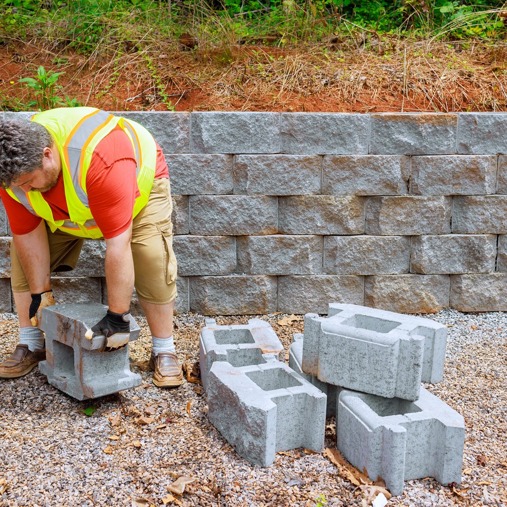 Man lifting block for retaining wall construction