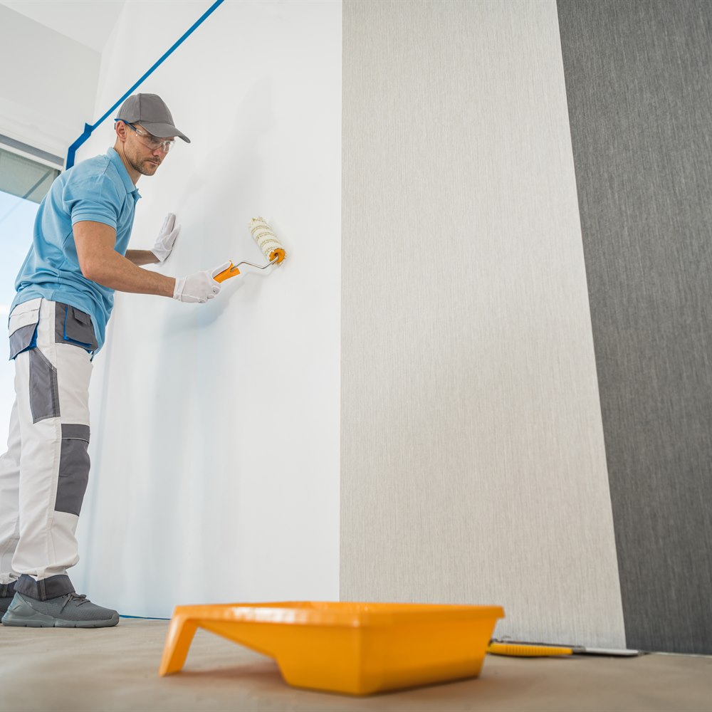 Man painting a wall with a roller