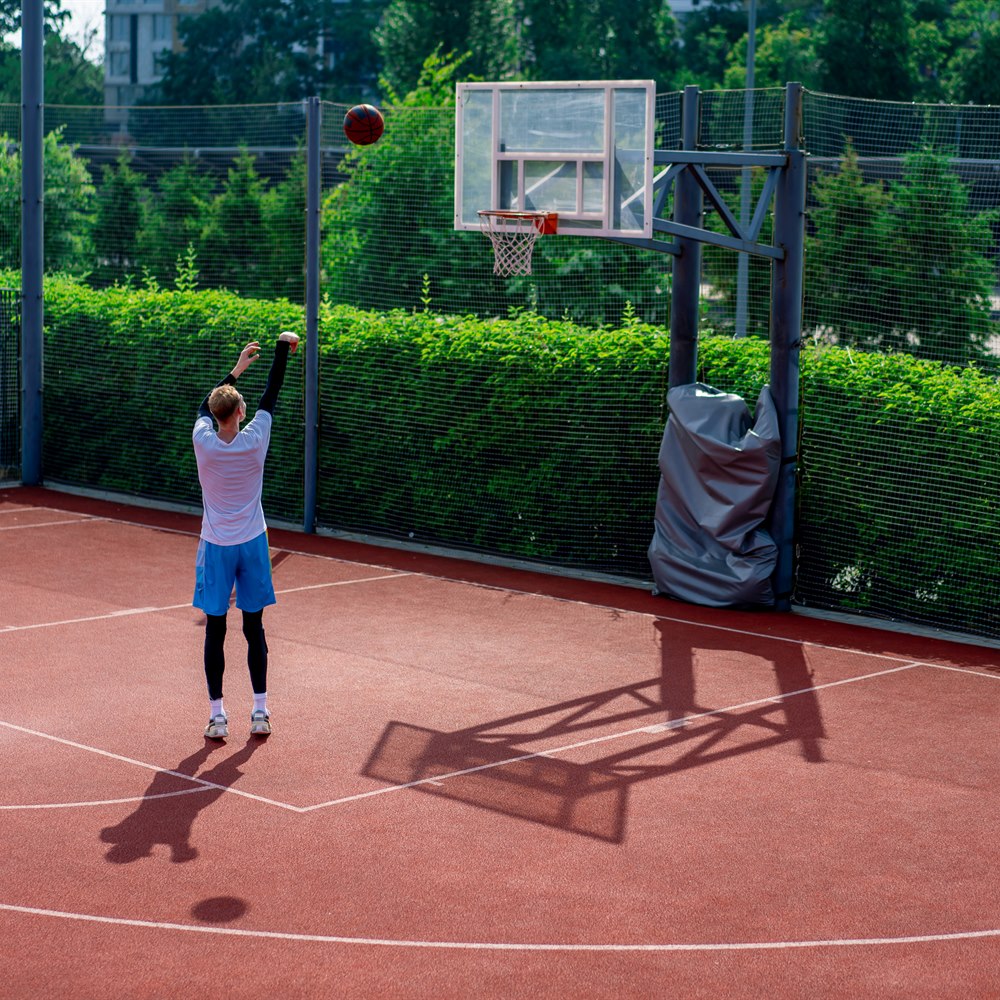 Man practicing basketball skills at outdoor court