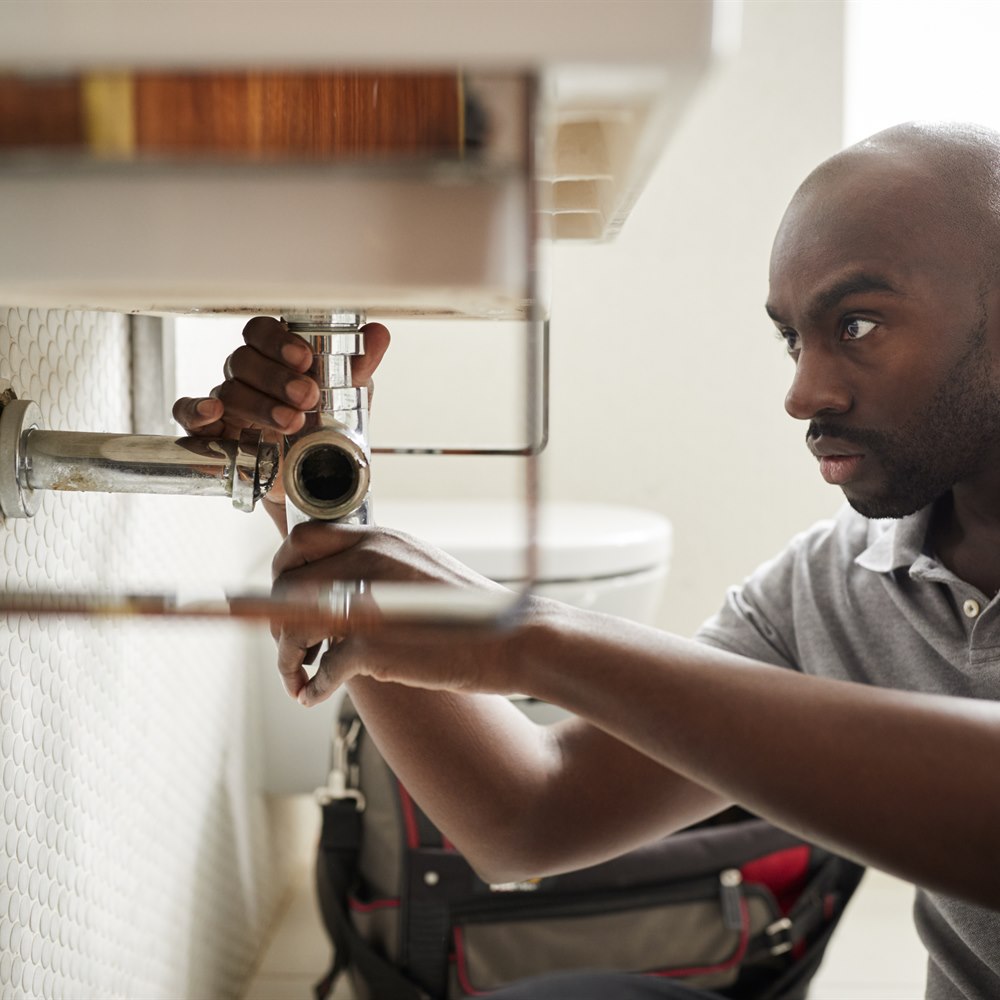 Man repairing a sink in the bathroom