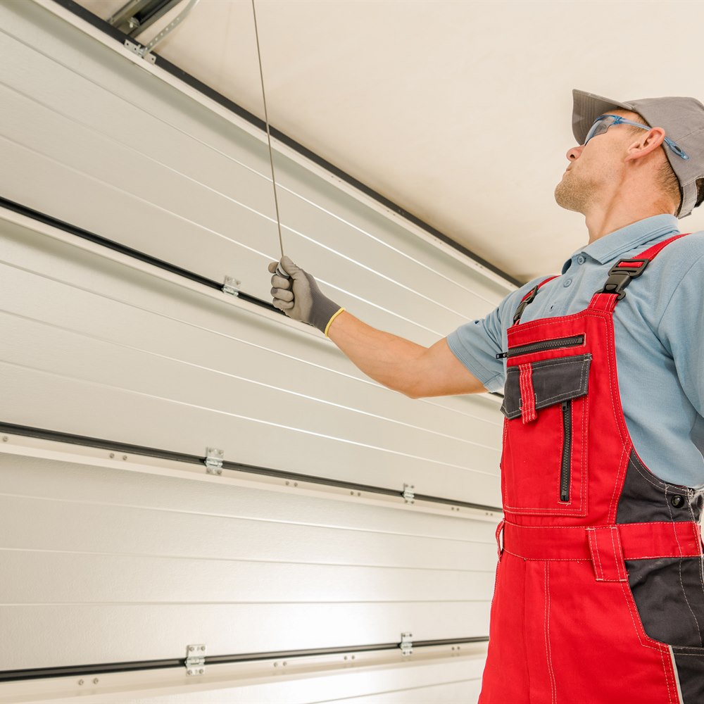 Man repairing garage door in indoor workplace